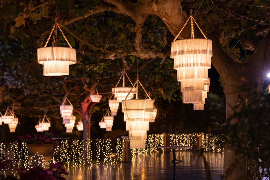 Lámparas de cristal colgadas de los árboles del jardín de El Atrio, de noche