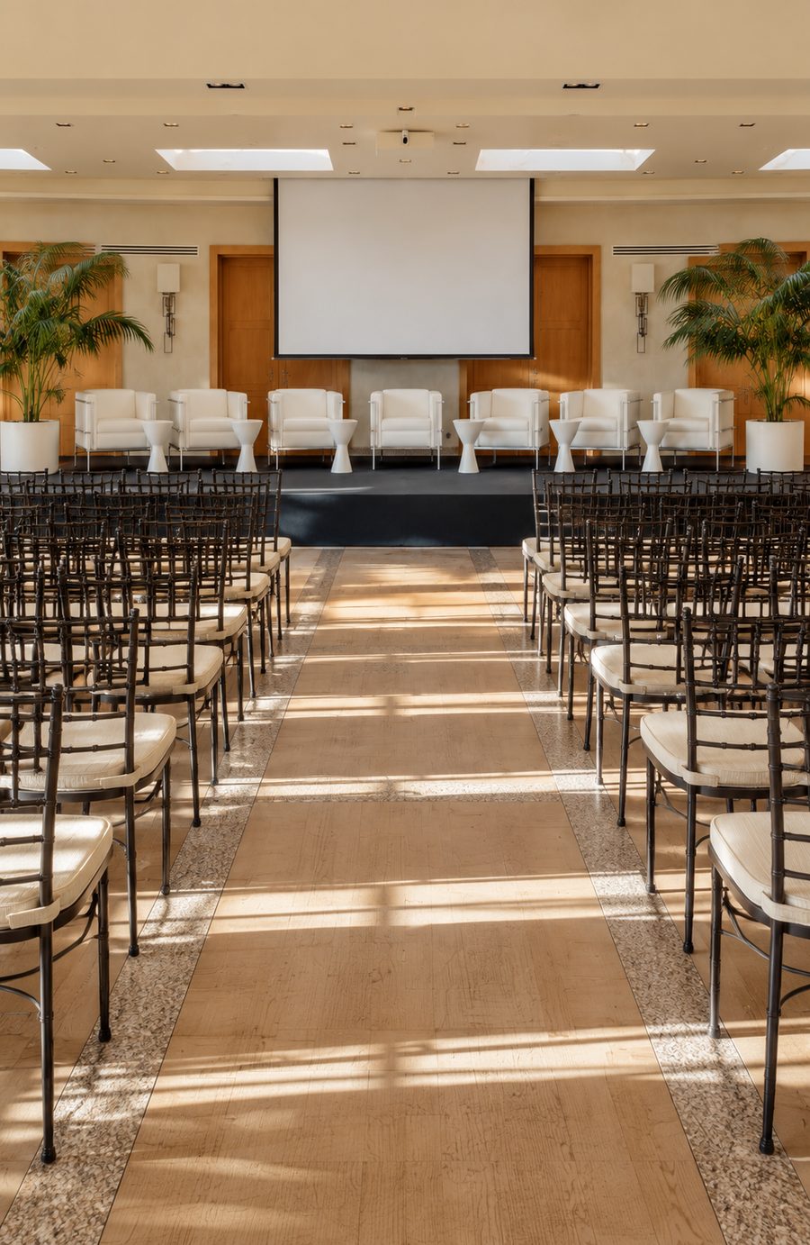 Sala montada en formato teatro con pantalla para una presentación de empresa