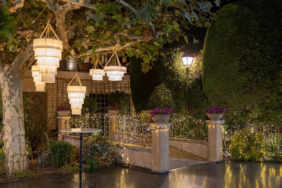 Lámparas de cristal colgadas de los árboles del jardín de El Atrio, de noche